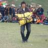 Tibetan man competing in rock carrying game at Lhagang Horse Festival.&nbsp;