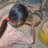Woman in the Kitchen making Jar out of brewed millet