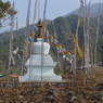 Chorten surrounded by prayer flags in middle of the fields